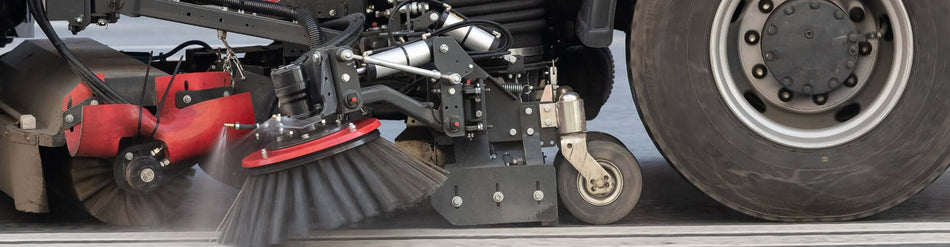 Close-up of a street sweeper's brush and wheel, designed for efficient debris collection in urban areas.