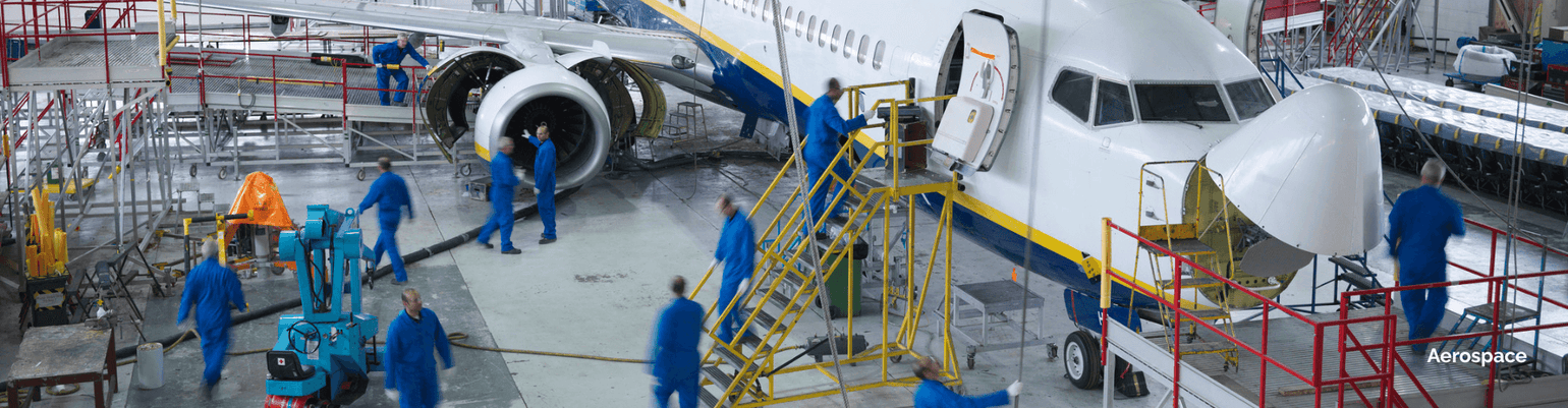 Aircraft maintenance in a hangar, showcasing skilled workers servicing a commercial jet engine.