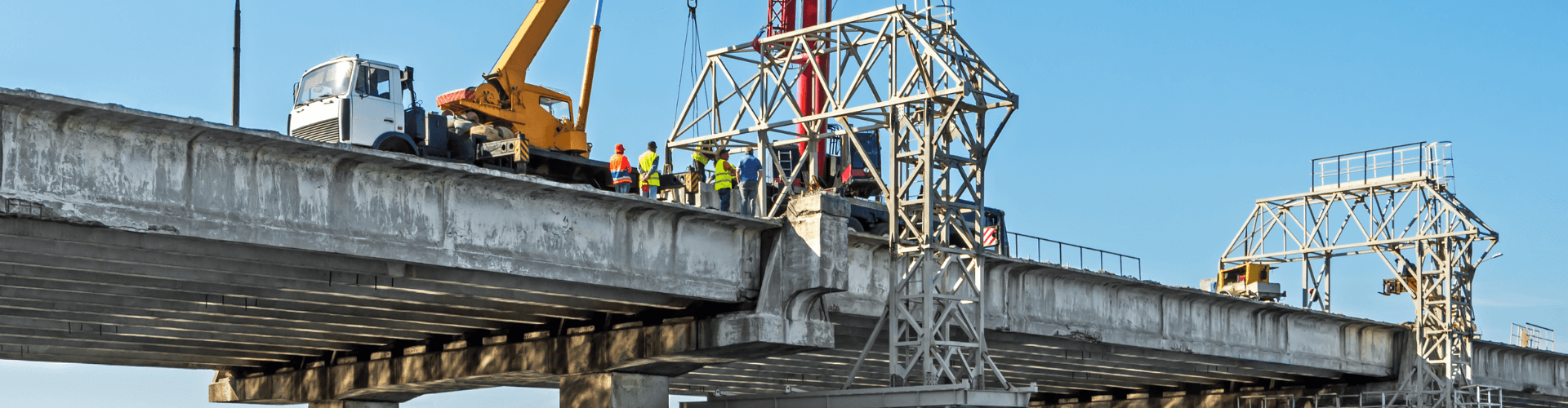 Workers performing maintenance on a bridge, showcasing bridge cleaning and vacuum filtering operations.