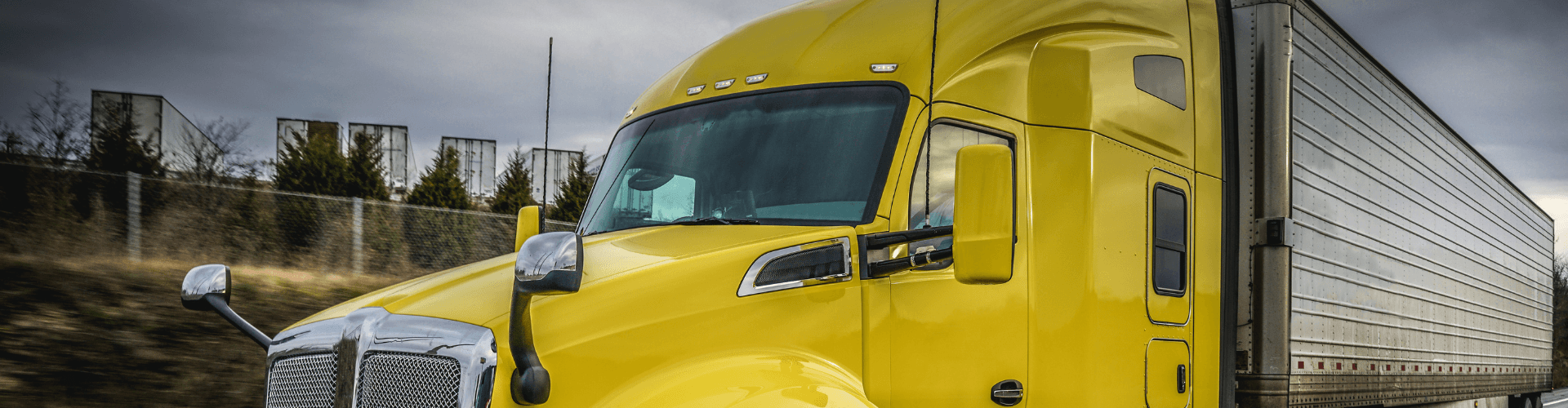 Close-up of a bright yellow truck showcasing cab ventilation for improved airflow and climate control.