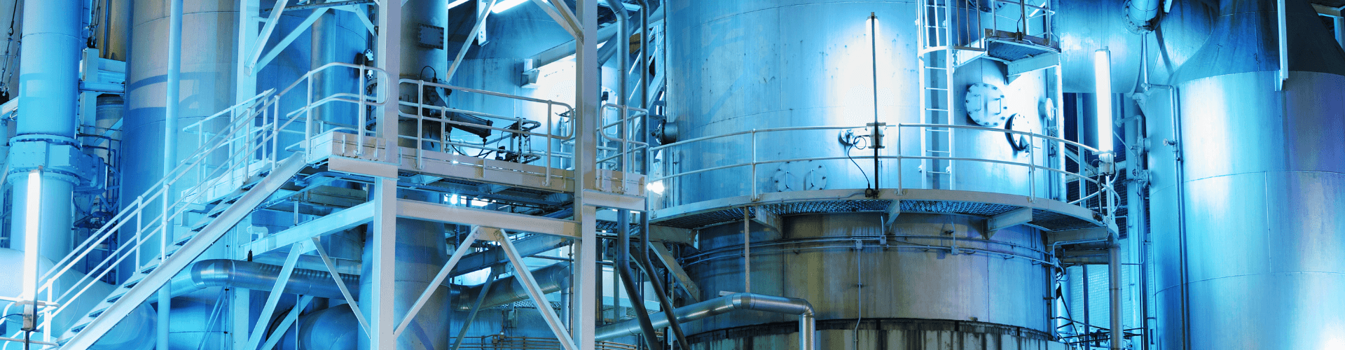 Industrial chemical plant showcasing advanced processing equipment and infrastructure with blue lighting.