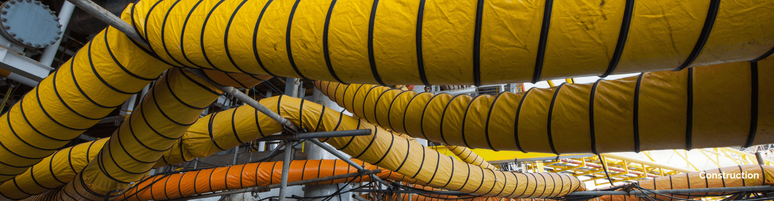 Colorful industrial hoses used in construction for dust control and debris suction in rugged environments.