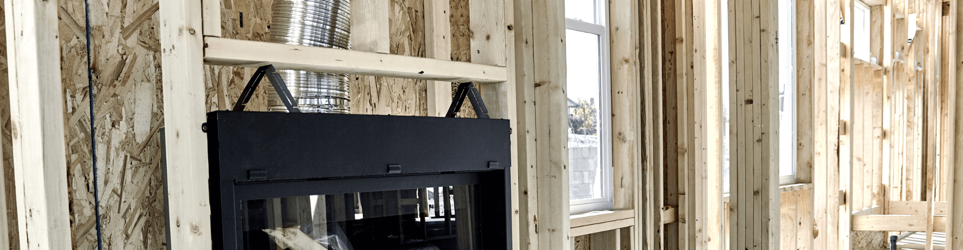 Modern fireplace insert being installed in a wooden-framed structure, showcasing venting options for compact spaces.