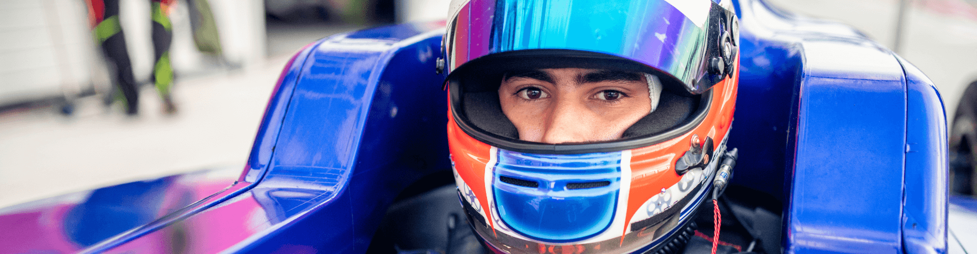 Race car driver wearing a ventilated helmet for optimal airflow in a racing environment.