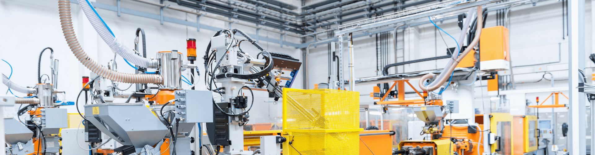 Injection molding setup with fume extraction systems and automated machinery in a modern industrial facility.