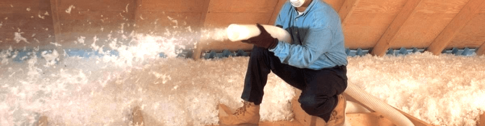 Worker blowing loose-fill insulation into attic for efficient thermal performance and energy savings.