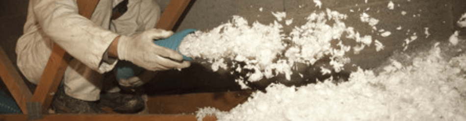 Technician blowing insulation with a hose, showcasing insulation blowing and removal versatility.