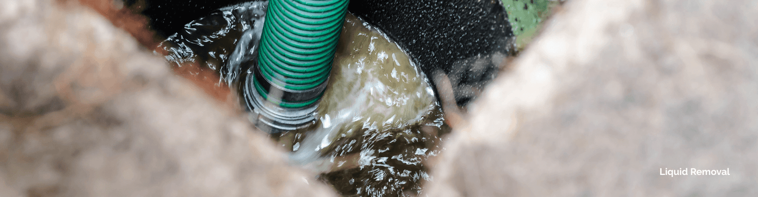 Flexible green hose in a pump system, transferring liquid waste for efficient removal.