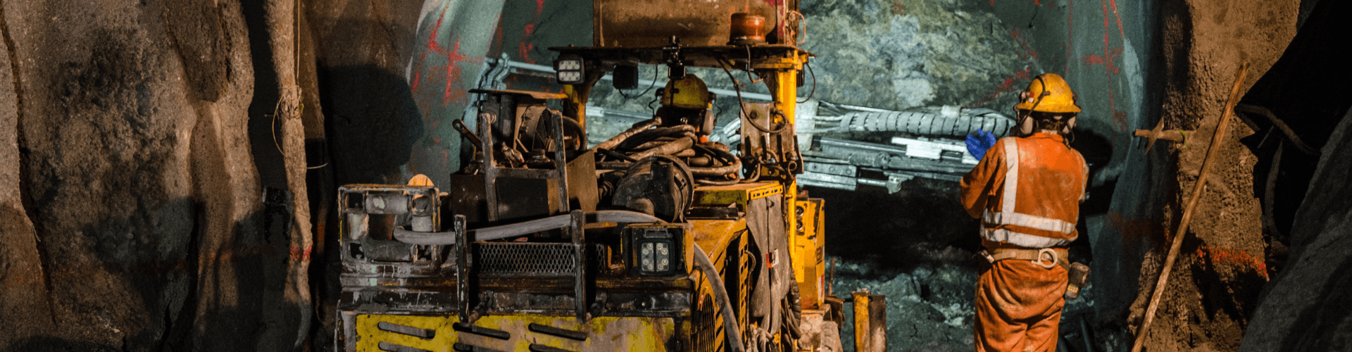 Mining crew using machinery for ventilation and fume removal in an underground tunnel.