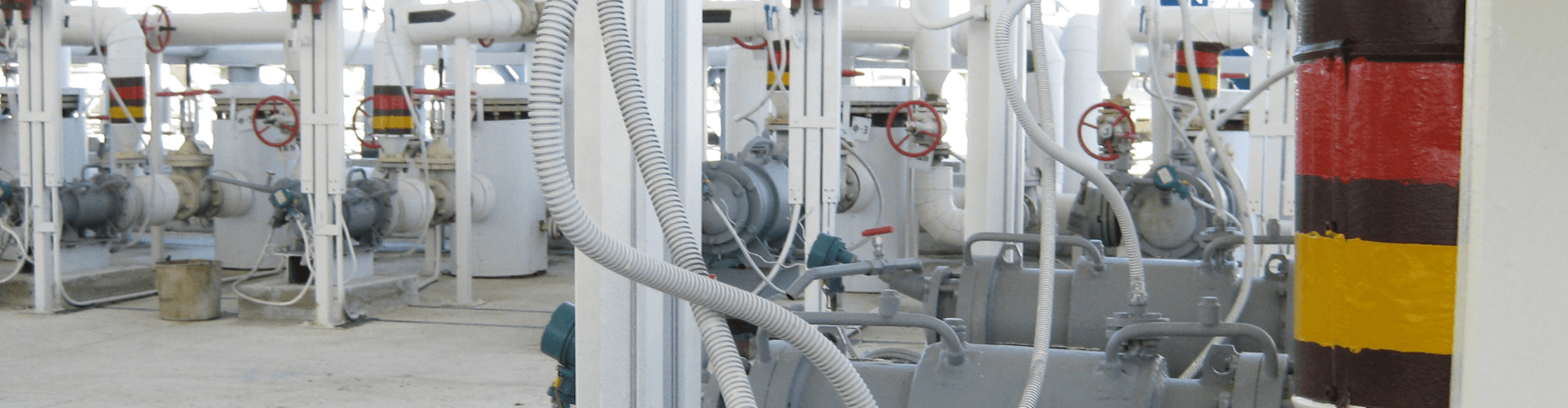 Inside a manufacturing facility featuring piping systems and oil mist extraction hoses for efficient mist removal.