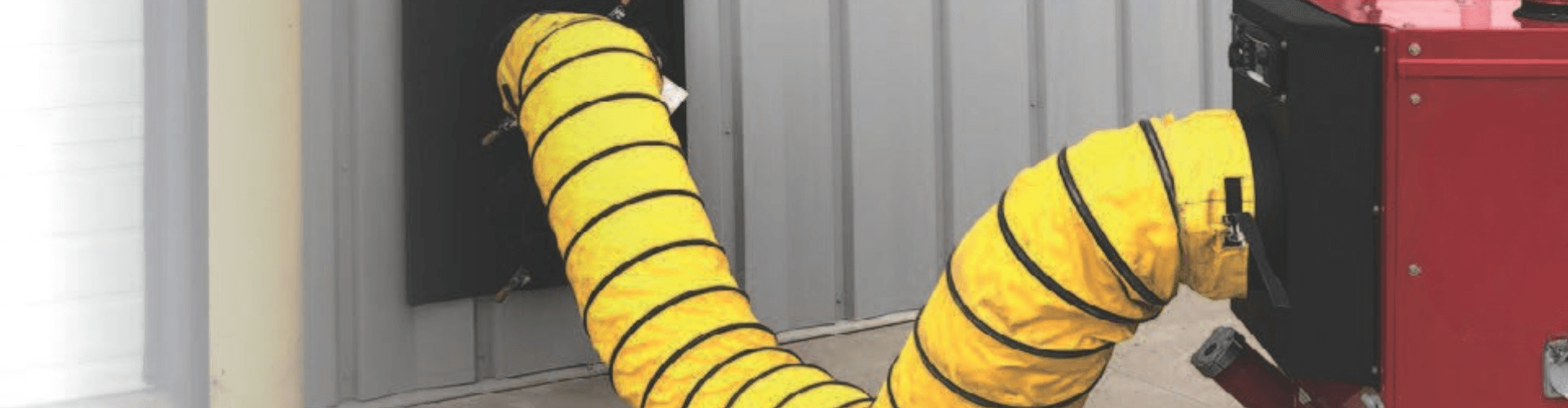 Yellow heat-tolerant hose connected to a portable heating unit, ideal for temporary setups at job sites and events.
