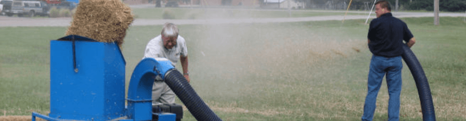 Operators using a straw blower for erosion control and agricultural coverage, demonstrating its efficiency and durability.