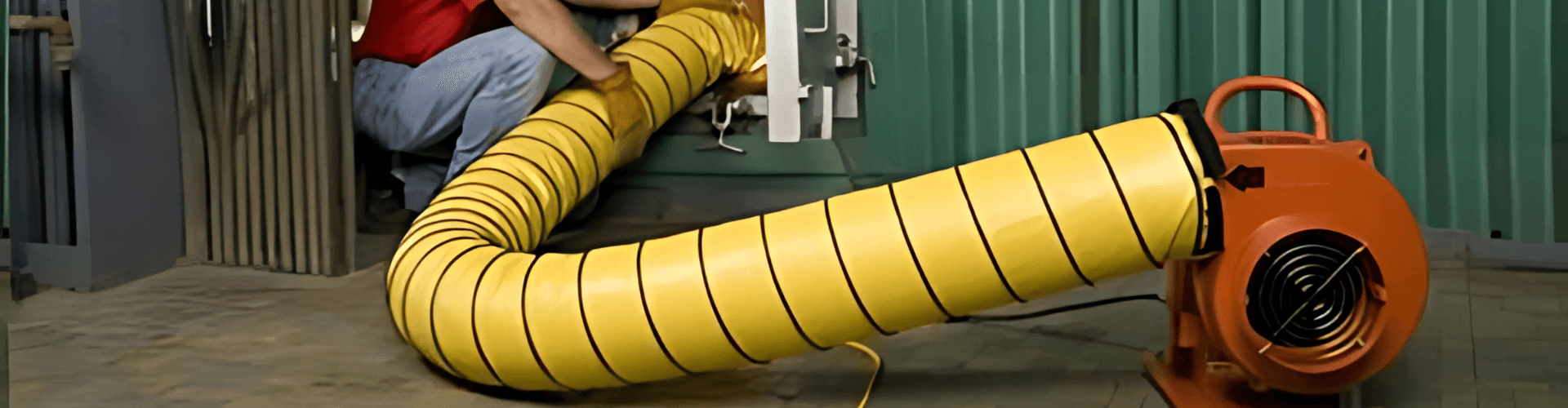 Worker using thermo-insulated yellow hose connected to HVAC unit for effective heating and cooling.