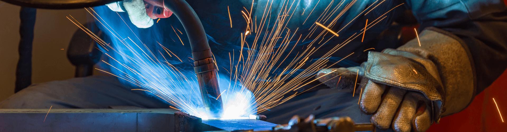 Welding process showing sparks and fume extraction, emphasizing safety and efficiency in welding zones.