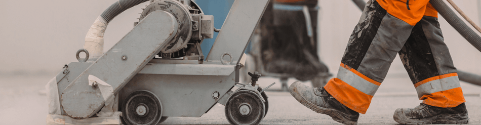 Worker operating a concrete drying machine for efficient ventilation in surface preparation.