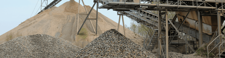 Industrial site showcasing piles of sand and gravel with machinery for heavy-duty suction and processing.