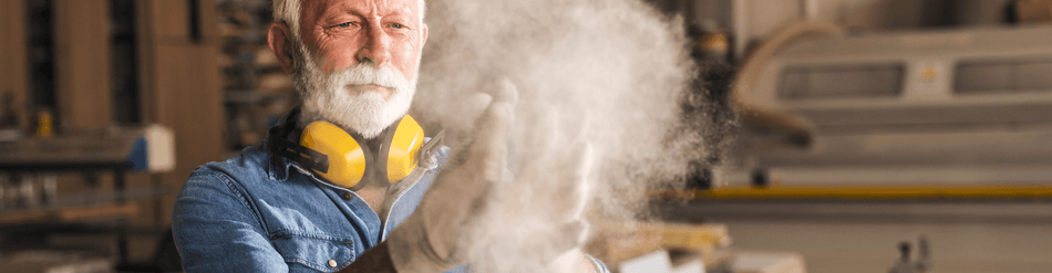 Worker removing silica dust in a workshop, showcasing safe practices with protective gear and effective air quality management.