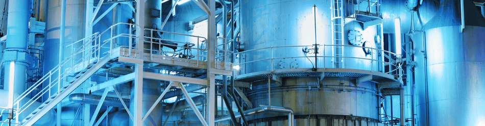 Industrial chemical plant showcasing advanced processing equipment and infrastructure with blue lighting.