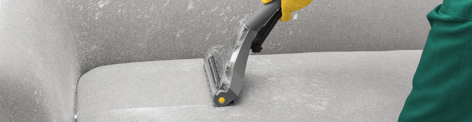 Cleaning upholstery with a specialized hose for furniture care, demonstrating effective spot cleaning techniques.