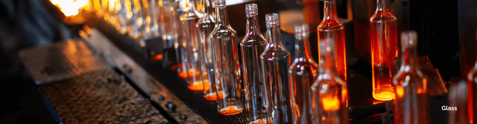 Row of glass bottles in production, showcasing heating processes and precision glasswork for quality control.