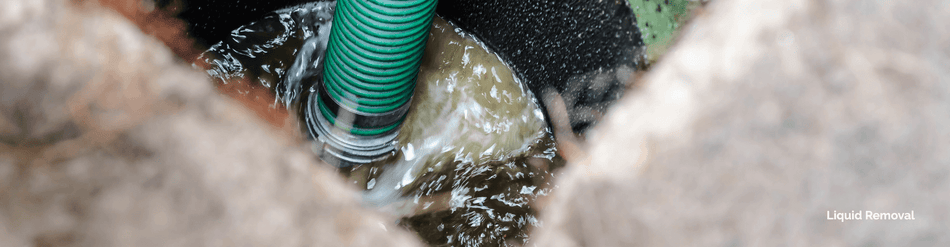 Flexible green hose in a pump system, transferring liquid waste for efficient removal.