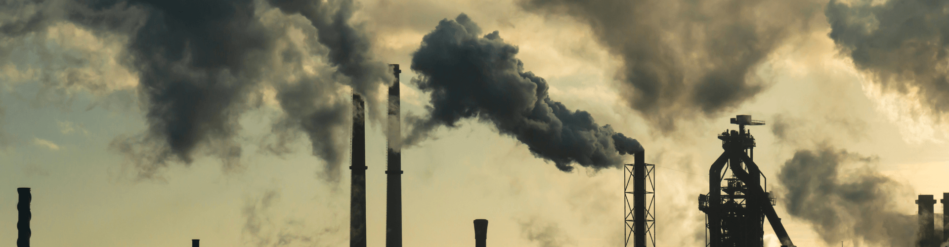 Industrial skyline with smoke emissions, highlighting pollution issues and the need for effective control systems.