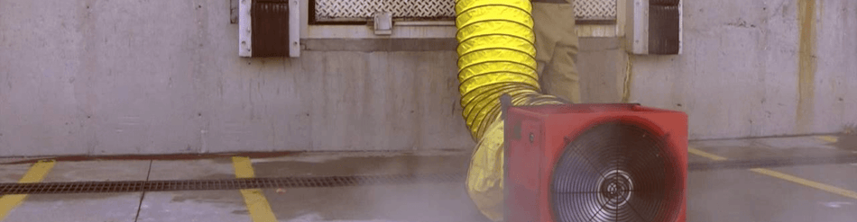 Smoke ejector fan with yellow duct for emergency ventilation in confined spaces.
