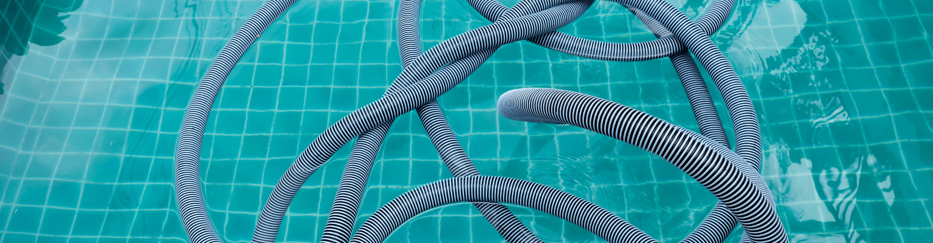 Flexible vacuum hoses coiled in clear blue water, ideal for wet vacuum systems and efficient liquid pick-up.