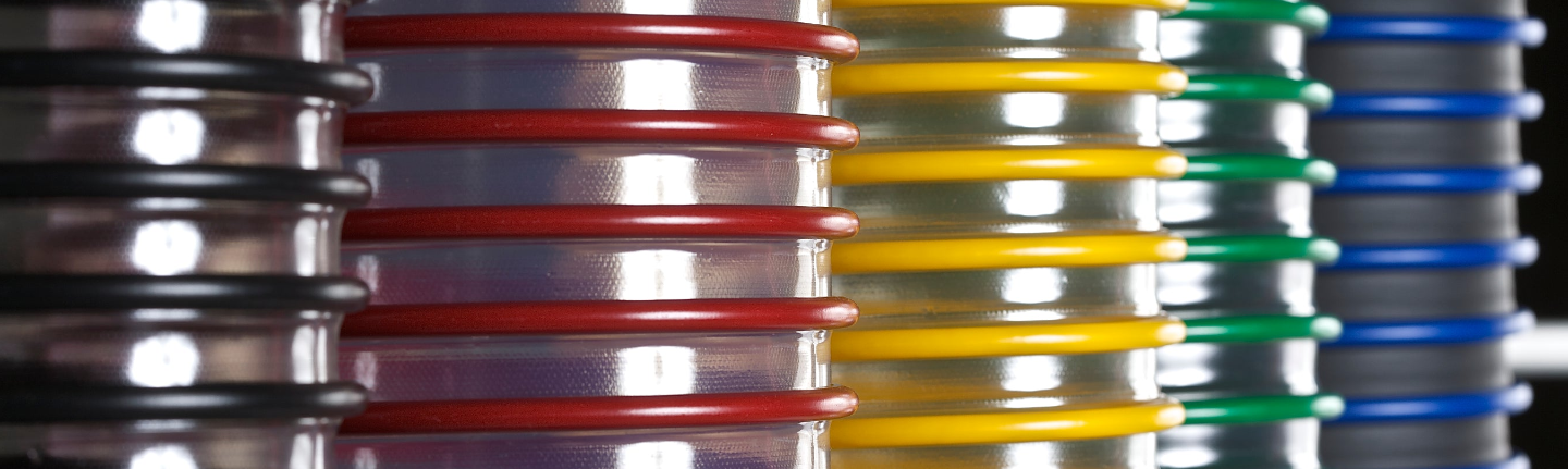 Stacks of colorful metal coils in red, yellow, green, and blue.