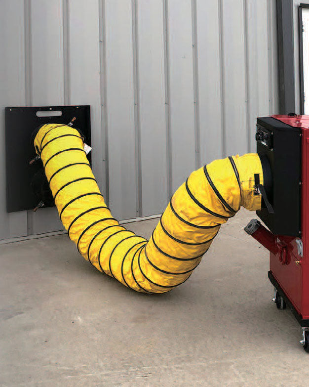 Yellow duct connected to a red machine against a gray wall.