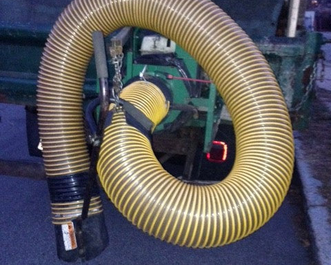 Yellow flexible hose coiled with machinery in the background