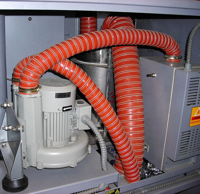 Close-up of industrial equipment with red hoses and a motor.