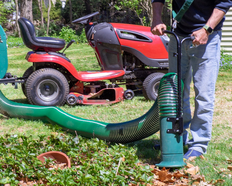 a man using a green leaf vacuum hose