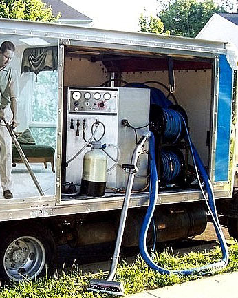 Trailer with cleaning equipment including a vacuum and hoses.