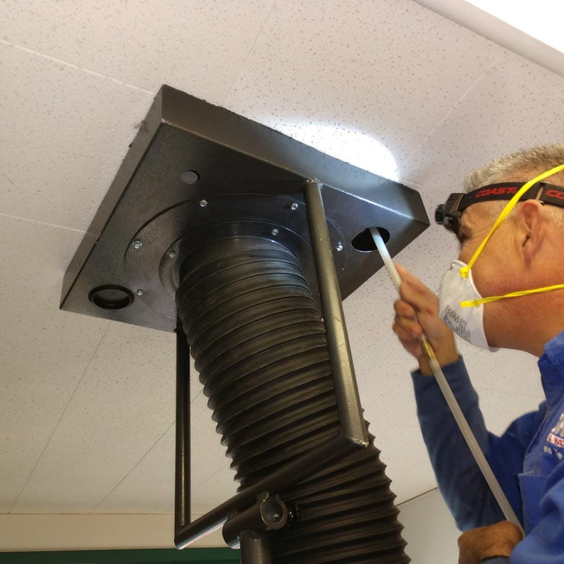 Person working on an air duct system with a ceiling vent